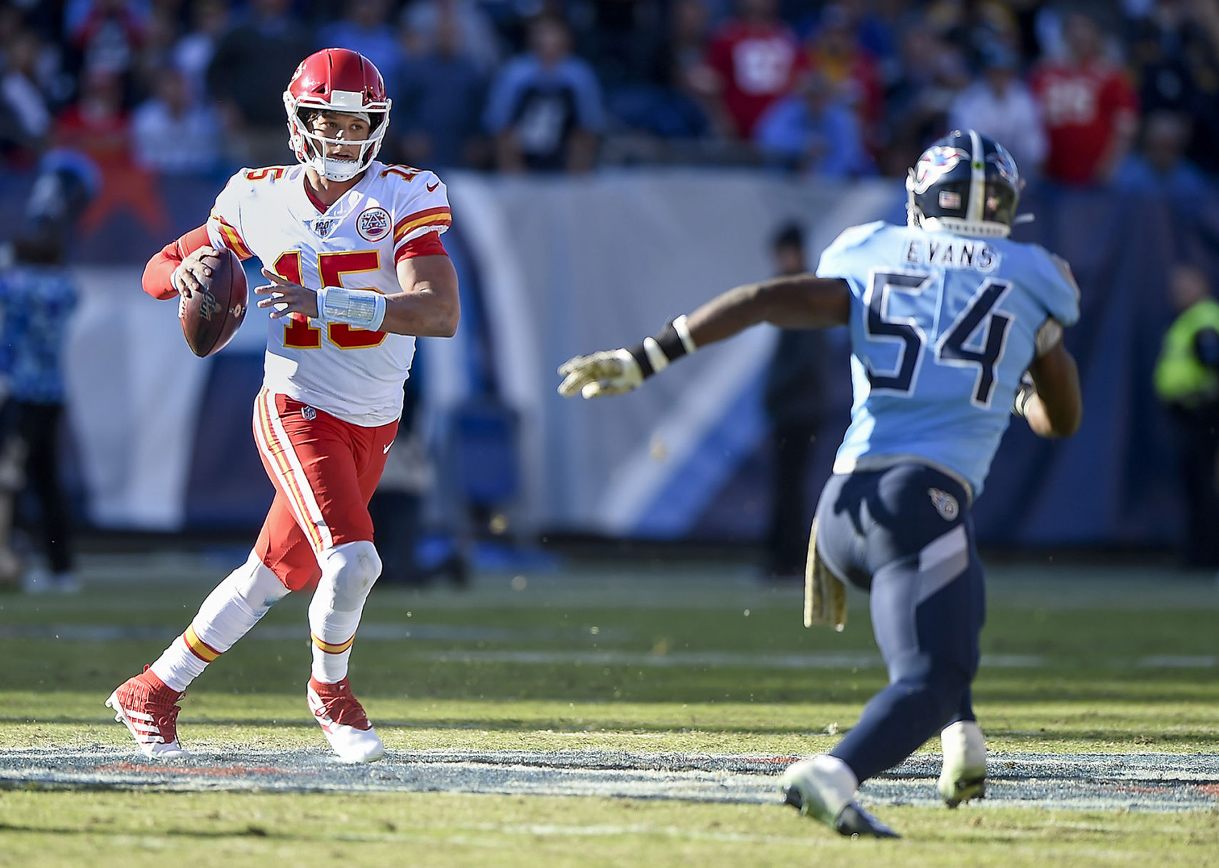 Kansas City Chiefs quarterback Patrick Mahomes (15) scrambles from Tennessee Titans inside linebacker Rashaan Evans (54) before getting a pass off on Sunday, Nov. 10, 2019, at Nissan Stadium in Nashville, Tenn.